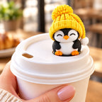 Sleepy Penguin with yellow hat on a coffee cup lid